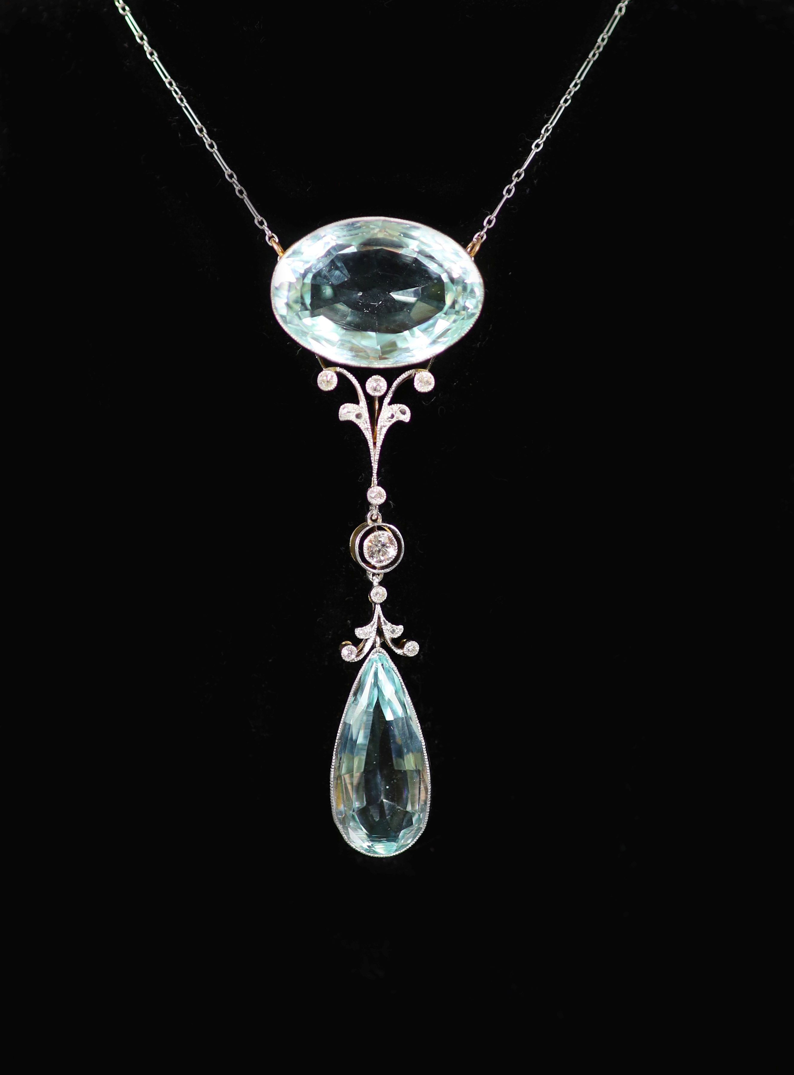 An early 20th century gold and platinum, millegrain set diamond and two stone aquamarine set drop pendant necklace, with a fine link platinum chain